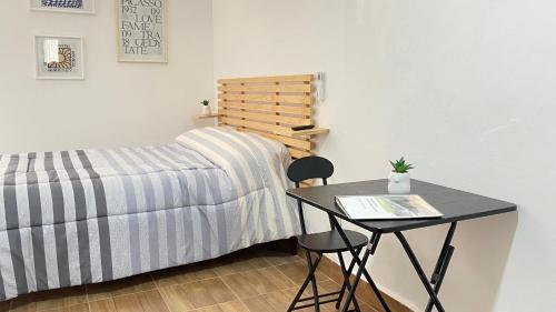 韦拉克鲁斯Loft en Veracruz的一间卧室配有桌子、床、桌子和椅子