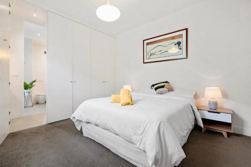 墨尔本St Kilda Style - Stunning 3 Bedroom House的白色卧室配有一张带白色床单的大床