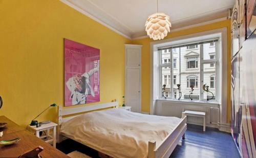 哥本哈根Copenhagen Apartment with excellent location的黄色的房间,设有床和窗户