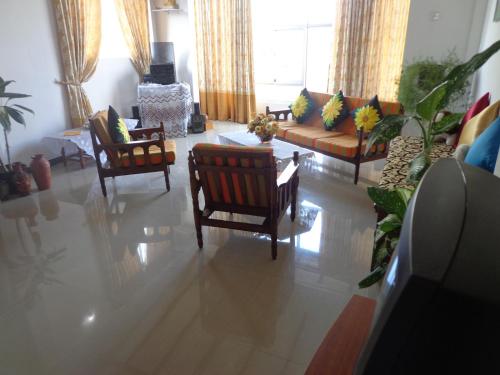 卡卢特勒Asoka Resident Kalutara的客厅配有椅子和沙发