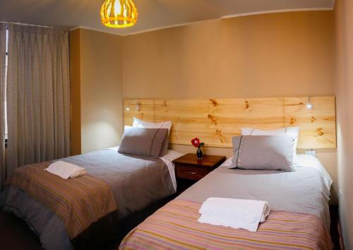 奇瓦伊Colibrí Inn的酒店客房设有两张床和吊灯。