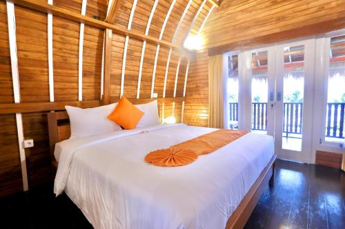 坎古37 Sunset Village Bali的一间卧室配有一张带橙色遮阳伞的床。