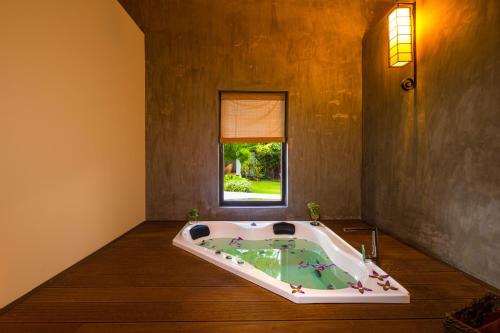蒂瑟默哈拉默Chaarya Resort & Spa的一个带窗户的客房内的按摩浴缸