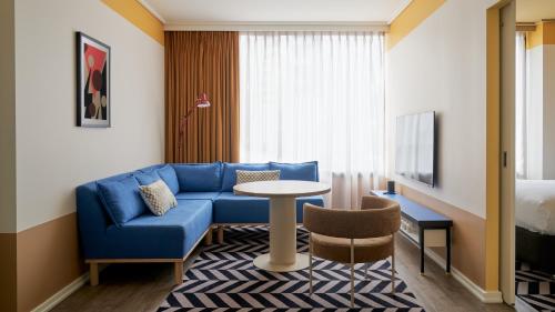 墨尔本Laneways by Ovolo的酒店客房配有蓝色的沙发和桌子
