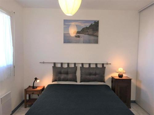 布科·莱斯白老城Appartement Vieux-Boucau-les-Bains, 2 pièces, 4 personnes - FR-1-379-74的一间卧室配有一张大床和一盏灯