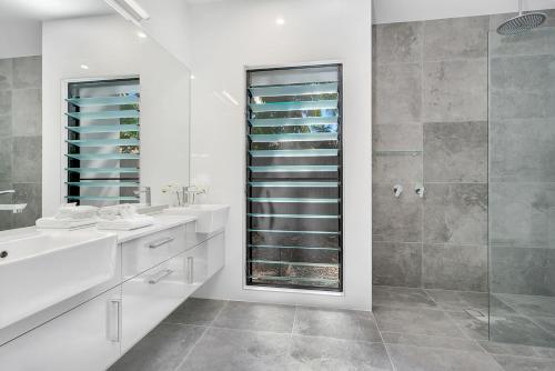 克利夫顿海滩Tiino Villa with Heated Pool Clifton Beach的带淋浴、盥洗盆和镜子的浴室