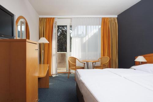 布尔诺OREA Hotel Voro Brno的酒店客房配有一张床铺和一张桌子。