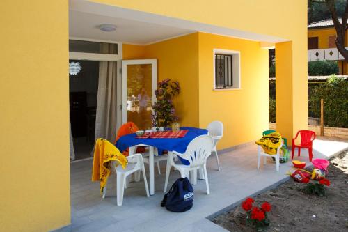 罗索利纳马雷Principesse的一个带桌椅的庭院和一座黄色的房子