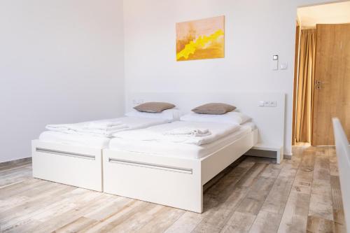 兹诺伊莫Penzion Vinařství Konitz的卧室配有两张白色的床。