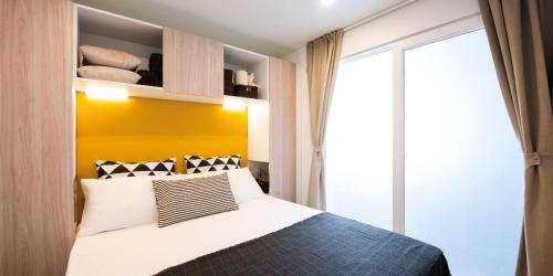 巴里萨尔多Camping villaggio L'Ultima spiaggia的一间卧室配有一张黄色墙壁的床