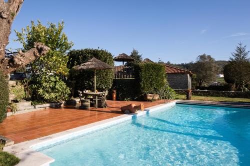 孔迪镇金塔索米格尔阿科斯酒店的一座带房子的庭院内的游泳池