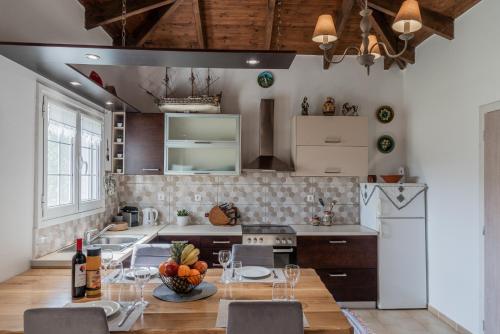 PandokrátorArmando Cottage的带桌椅的厨房以及带白色家电的厨房。