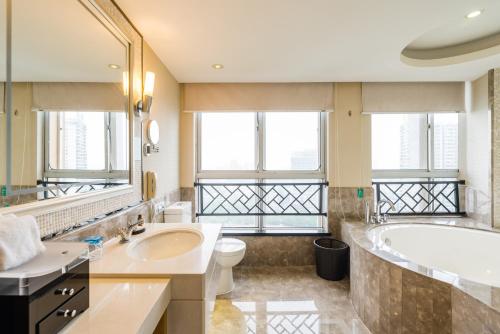 九江九江远洲国际大酒店的带浴缸、卫生间和盥洗盆的浴室