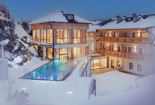圣迈克尔隆高Hotel Weissenstein的雪中带游泳池的房子
