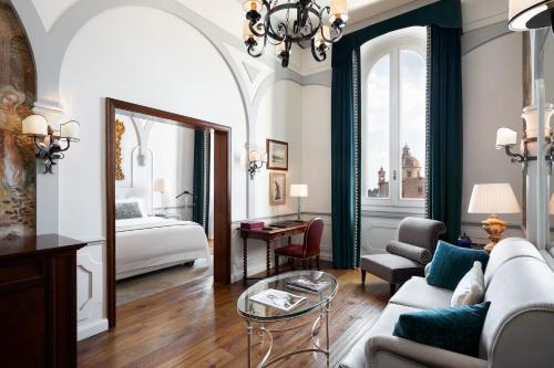 佛罗伦萨佛罗伦萨瑞吉酒店的客厅配有沙发和1张床