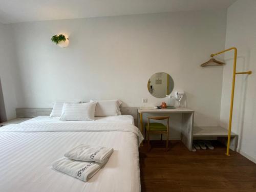 马六甲旅乐酒店的一间卧室配有一张床和一张带镜子的桌子