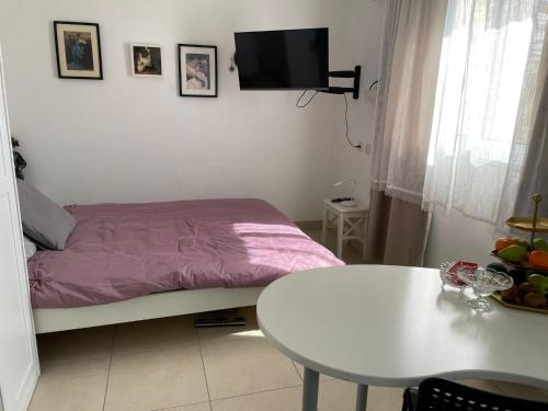 兹奇隆亚科夫my holiday apartment的一间小卧室,配有一张床和一张桌子