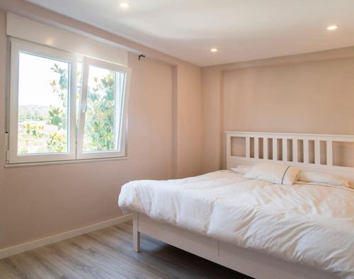 切尔韦洛20 min from BCN- Charming house w/ pool & BBQ area的卧室配有白色的床和窗户。