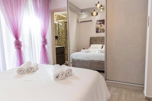 比雷埃夫斯Piraeus Port Exclusive的一间卧室配有两张床、粉红色窗帘和镜子