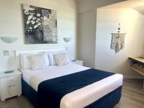 亚历山德拉岬角Ocean Views - Top floor的一间卧室配有一张带蓝白色床单的大床