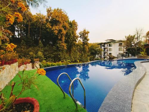 德拉敦Ataraxia Crestmont Resort & Spa的一座绿草环绕的大型游泳池