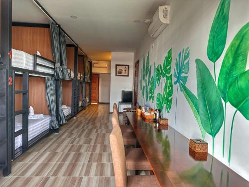 金边Monsoon Riverside Hotel的一间带长桌子和椅子的房间和一间卧室