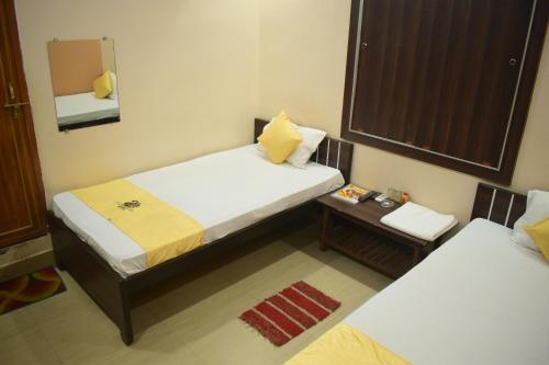 加雅Hotel Shakuntla Palace的小房间设有两张床和镜子