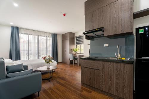 河内Granda Lake View Hotel & Apartment的厨房以及带床和沙发的客厅。