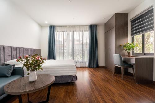 河内Granda Lake View Hotel & Apartment的酒店客房配有床、沙发和桌子。