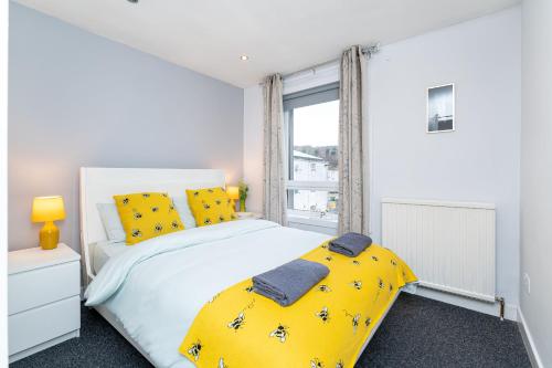 亚伦桥Lovely 3-bedroom flat with free parking的一间卧室配有一张带黄色枕头的床和一扇窗户