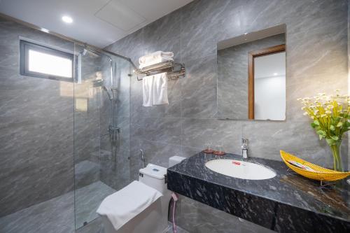岘港Samatha Apartment & Hotel的一间带水槽和玻璃淋浴的浴室