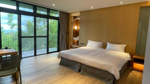 东河La Tree 普椿農場木子莊園的一间卧室设有一张大床和一个大窗户