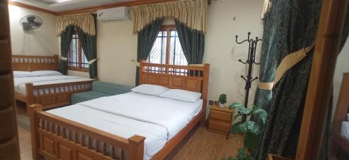 穆扎法拉巴德Eagle Nest Cottage Muzaffarabad by LMC的一间带两张床和一张沙发的小卧室