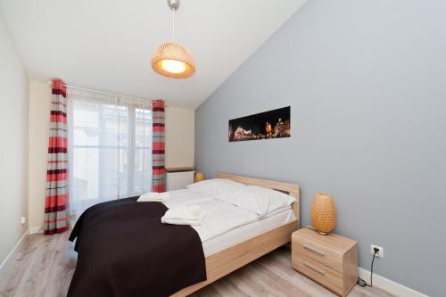 克拉科夫Apartamenty Sun & Snow Kraków Browar Lubicz的卧室配有一张床,墙上配有电视。
