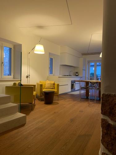 阿科Appartamento al castello di Arco的客厅以及带黄色椅子和桌子的厨房。