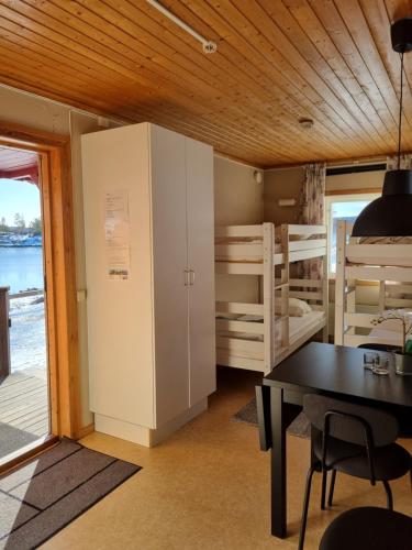 MåvikenMåvikens Camping的带桌子的房间和带双层床的房间