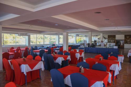 赫瓦尔Hotel Sirena Hvar的宴会厅配有红色和蓝色的桌椅