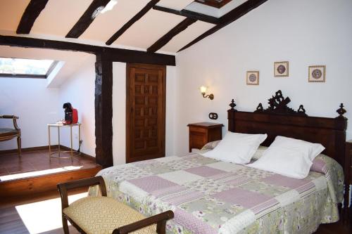 SelayaHabitaciones Casona De Linares的卧室配有1张床、1张桌子和1把椅子