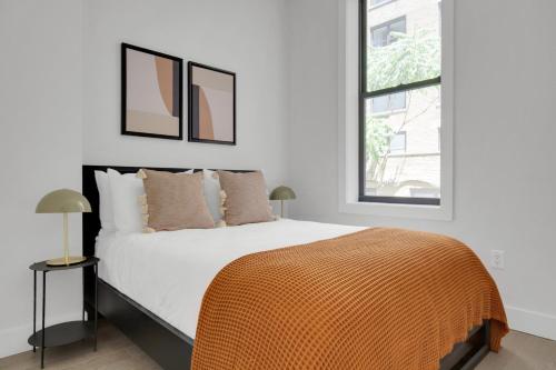 纽约UWS 1BR w Elevator WD nr Central Park NYC-857的一间卧室配有一张带橙色毯子的床