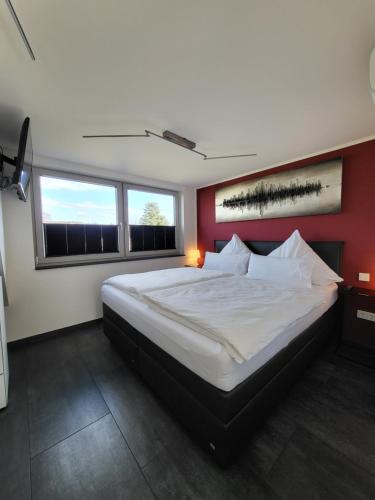 巴特诺因阿尔-阿尔韦勒Exklusive Wohnung mit Ahrblick 1 und Dachterrasse的一间卧室设有一张红色墙壁的大床