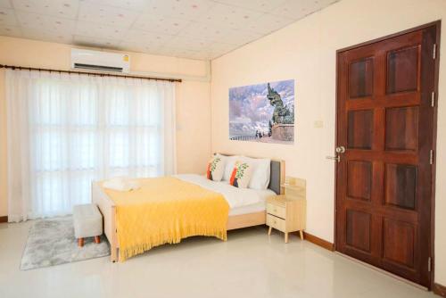 Ban Khao Rup Changที่พักสงขลา Homy garden Songkhla的一间卧室设有床、窗户和门