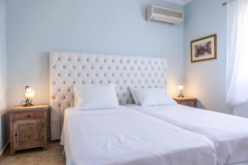 米尼亚Villa Alba Minies的卧室配有一张白色大床和2个床头柜