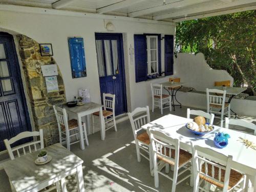 帕罗奇亚Onira的庭院配有白色桌椅和蓝色门