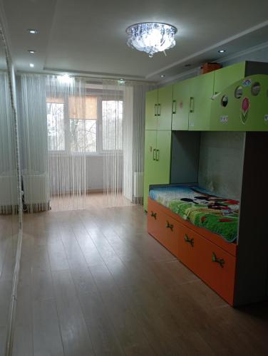 索罗卡Apartament cu 2 odai in chirie or.Soroca的一间设有一张床铺的卧室,位于一个设有绿色橱柜的房间