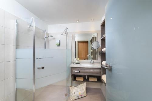 福森Hotel Sommer-Haus am See的一间带玻璃淋浴和水槽的浴室
