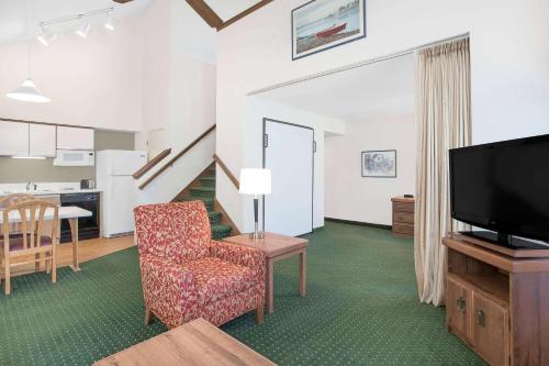 绿湾Hawthorn Extended Stay Hotel by Wyndham-Green Bay的客厅配有椅子和电视
