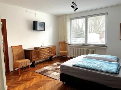 奥斯特霍尔茨-沙姆贝克Modern-Vintage Apartment的一间卧室配有一张床和一张带两把椅子的桌子