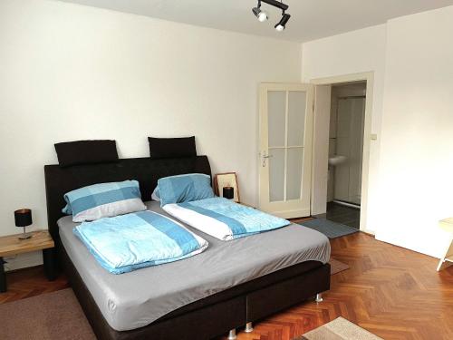 奥斯特霍尔茨-沙姆贝克Modern-Vintage Apartment的一间卧室配有一张带蓝色枕头的大床