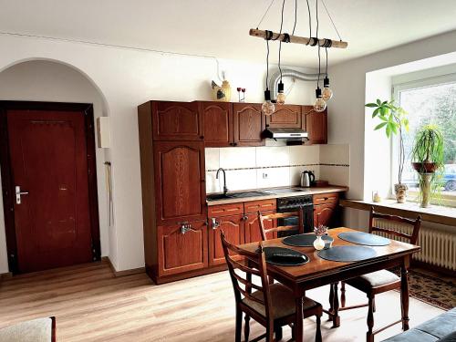 奥斯特霍尔茨-沙姆贝克Modern-Vintage Apartment的厨房配有木制橱柜和桌椅