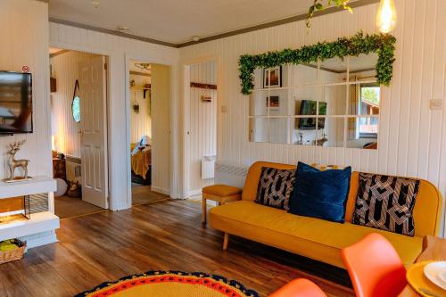 达农Wooden Cosy Retreat Hunters Quay的带沙发和镜子的客厅